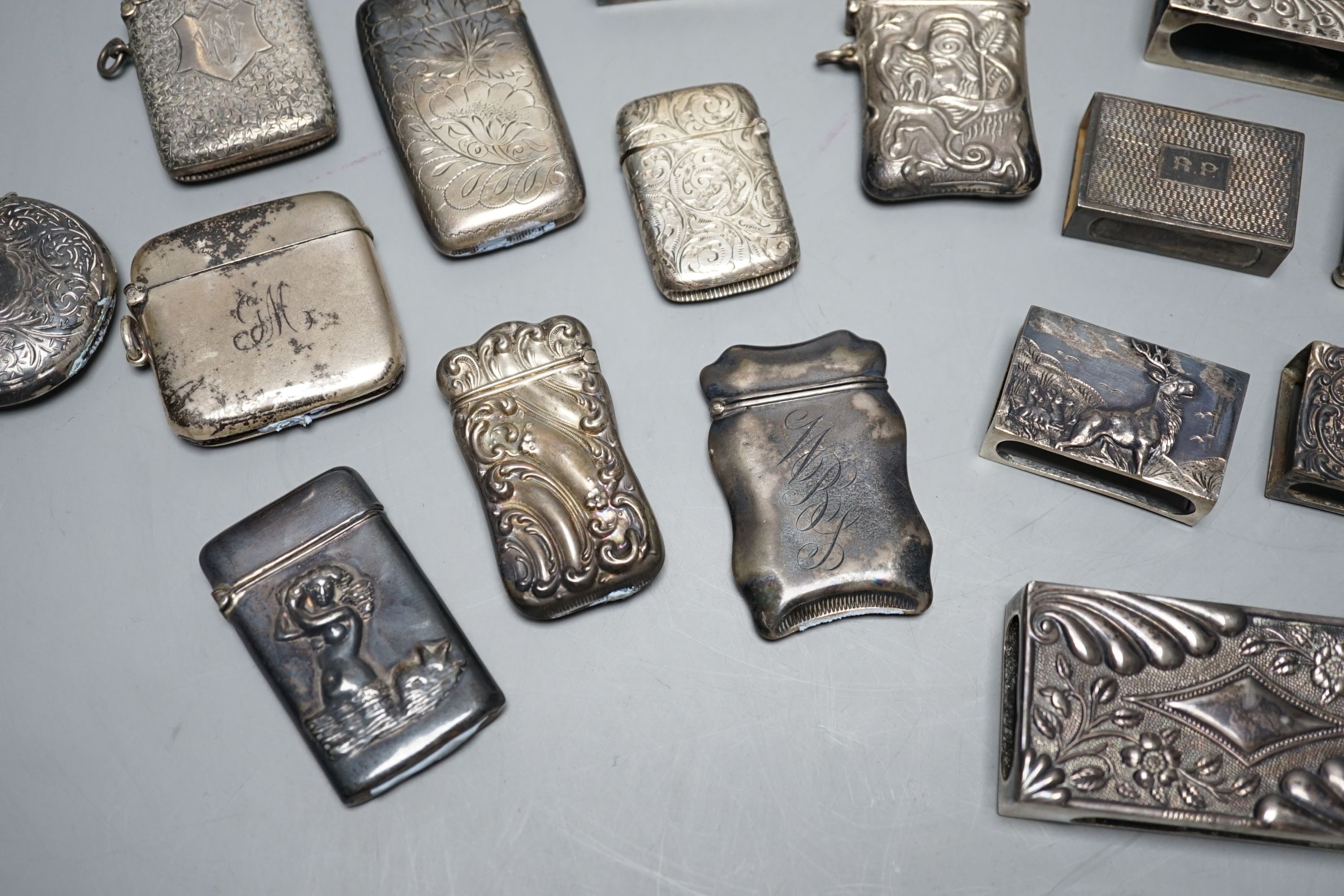 A small collection of nine mainly early 20th century silver or sterling vesta cases, largest 60mm and fourteen assorted similar silver or white metal match sleeves